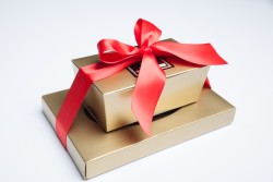 two gold candy boxes filled with toffee and nut clusters - woody candy company